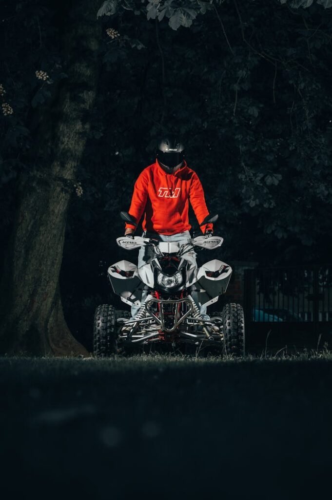 A Person in a Helmet Standing on an ATV